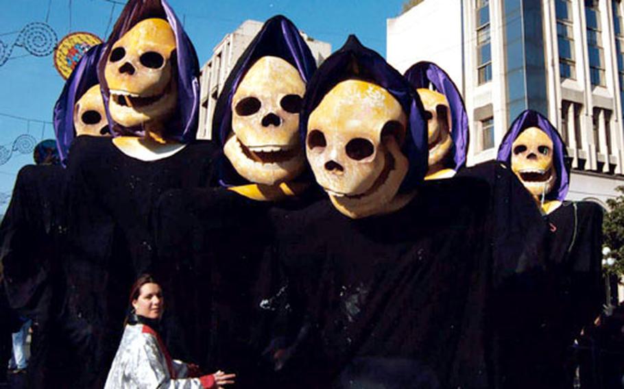 A group of Grim Reapers, 12 feet tall, pause with a carnivalgoer at Nice in 2003. The group represents the 11 o&#39;clock Grim Reaper News teams -- the worse the news, the better for the news team.