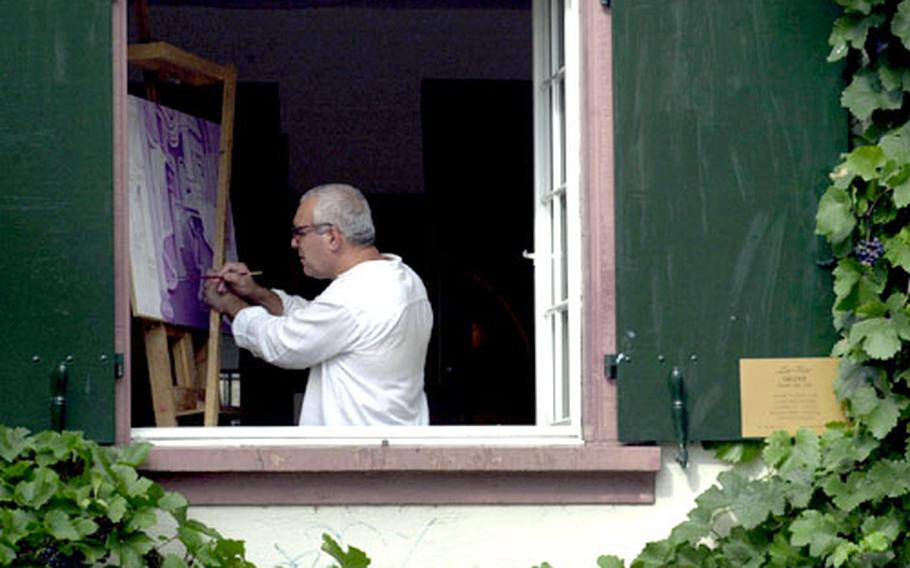 An artist at La Rev Galerie works in the fading summer dusk along the Oberer Rheiweg, along the north bank on the Small Basel side of the Rhine.