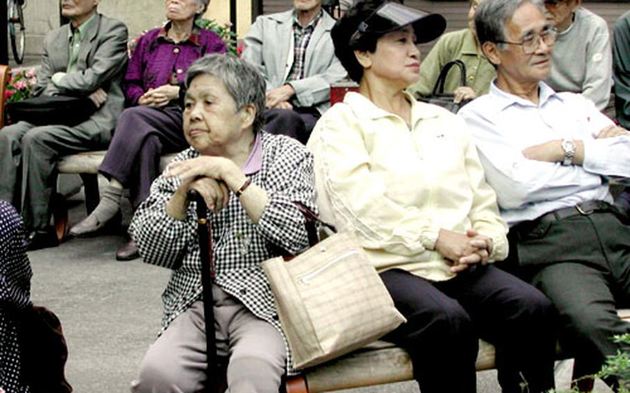 Older folks relax on benches inside the compound of Koganji Temple in Sugamo.