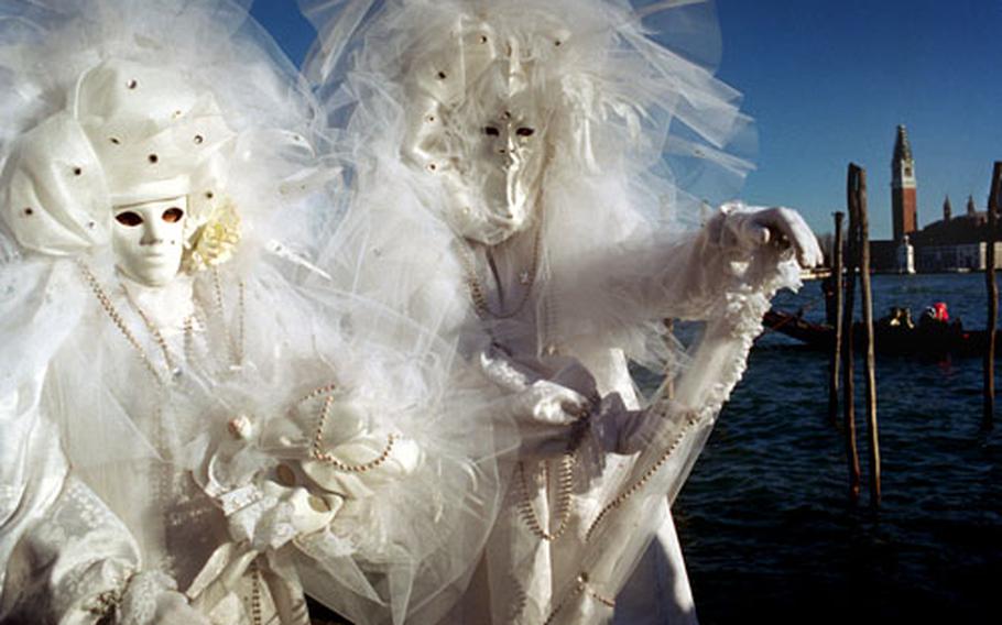 Revelers pose along the Bacino San Marco during the 1995 Carnevale de Venezia celebrations.