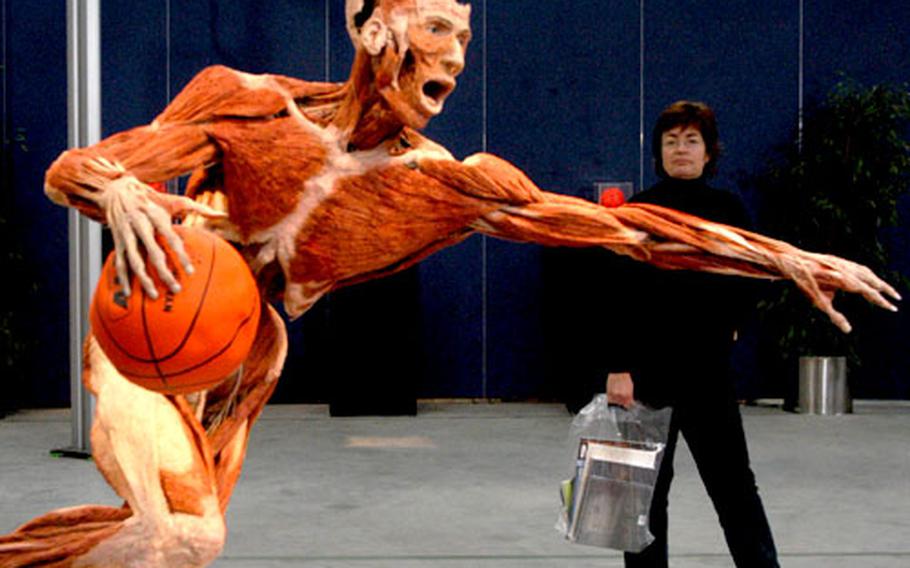 A visiting journalist walks past a basketball player.