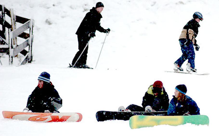 Snowboarding and ski students often collide during initial instruction at the Hausberg Lodge&#39;s "Back Yard" area used for instruction. Snowboarding students wait for further instruction about midway up the hill behind the Hausberg Lodge before practicing slipping down the hill forward and backward.