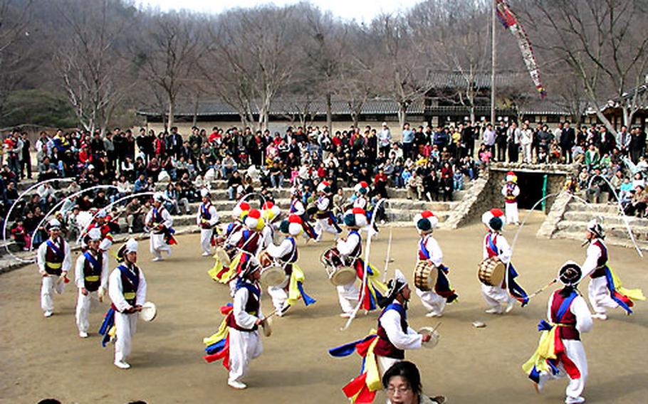 Dancers and musicians in traditional costume perform the farmer’s dance to the applause of several hundred spectators. The crowd reserves its warmest response for when the dancers leap and twist in midair.