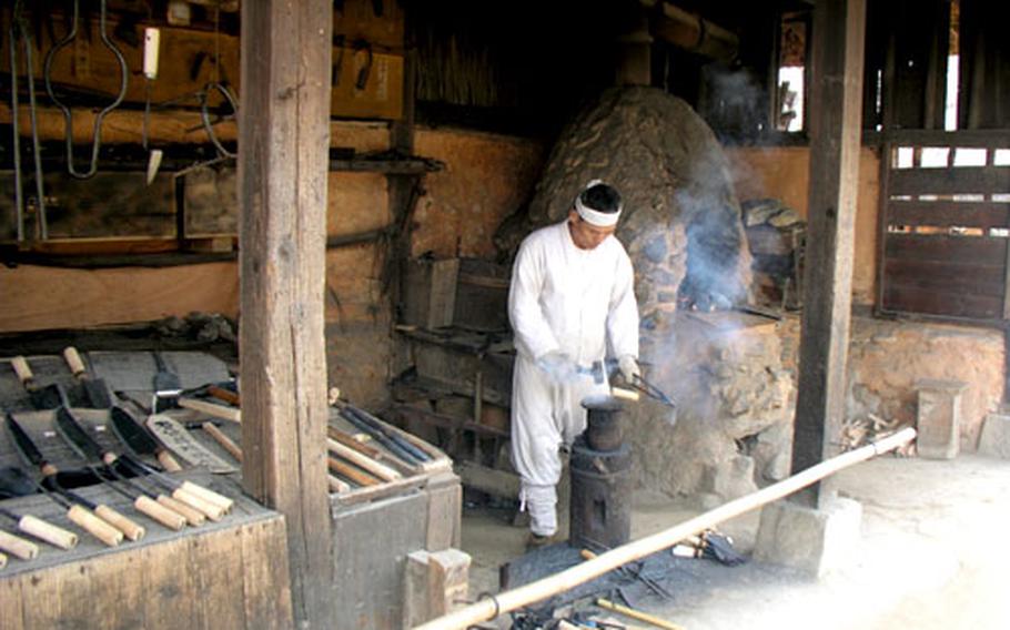Dressed in traditional Korean costume, this man enacts the role of a blacksmith.