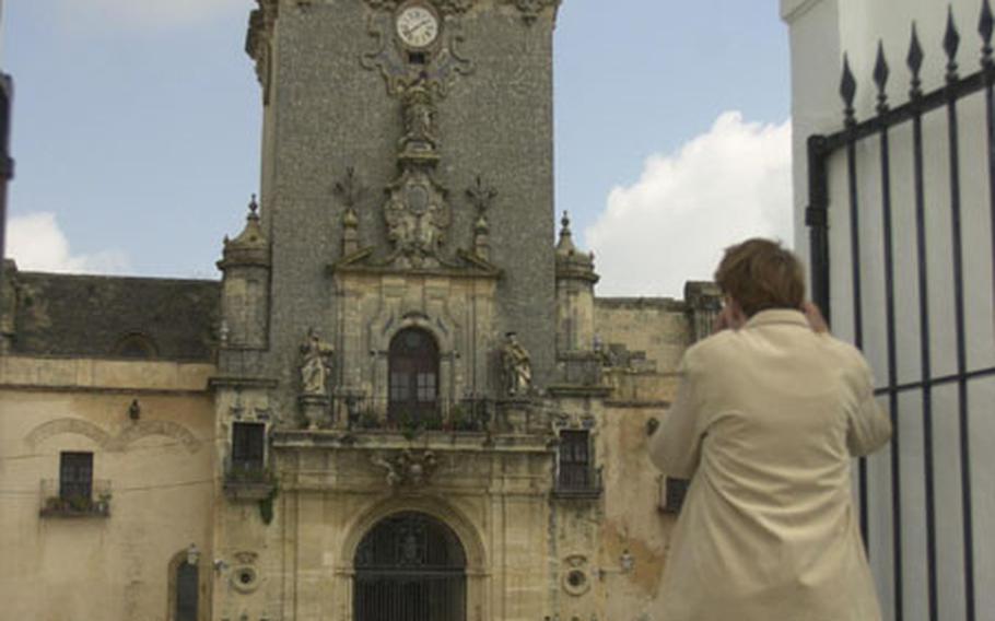 A tourist takes a photo of St. Mary’s Church in Arcos de la Frontera, Spain.