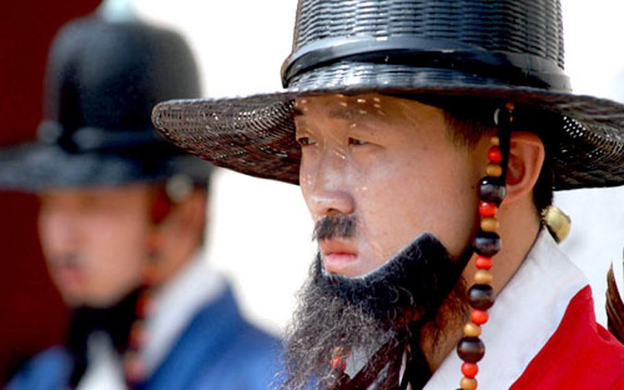 An actor playing a guard from the Chosun Dynasty stands outside Gyeongbok Palace.