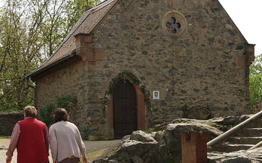 Two women walk up the hill to the chapel at Burg Frankenstein. The chapel, restored in the 1800s, is used today for weddings and other services.