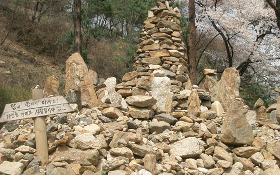 A rock tower along one of the paths in the lower part of Namsan park. The sign reads, "Don&#39;t touch a tower! Let&#39;s cherish and love nature!"