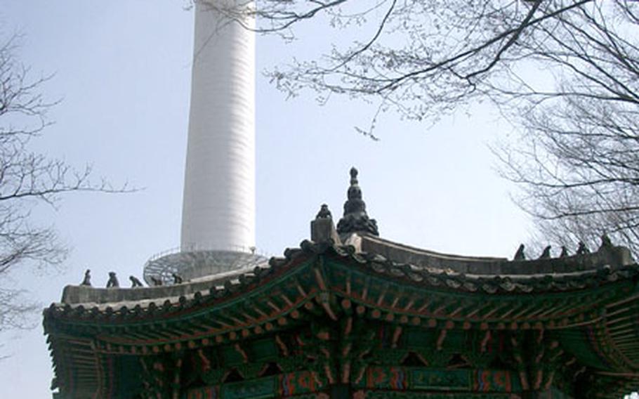 The old and the new ... Seoul Tower rises above a historic pavilion crowned with watching monkeys.