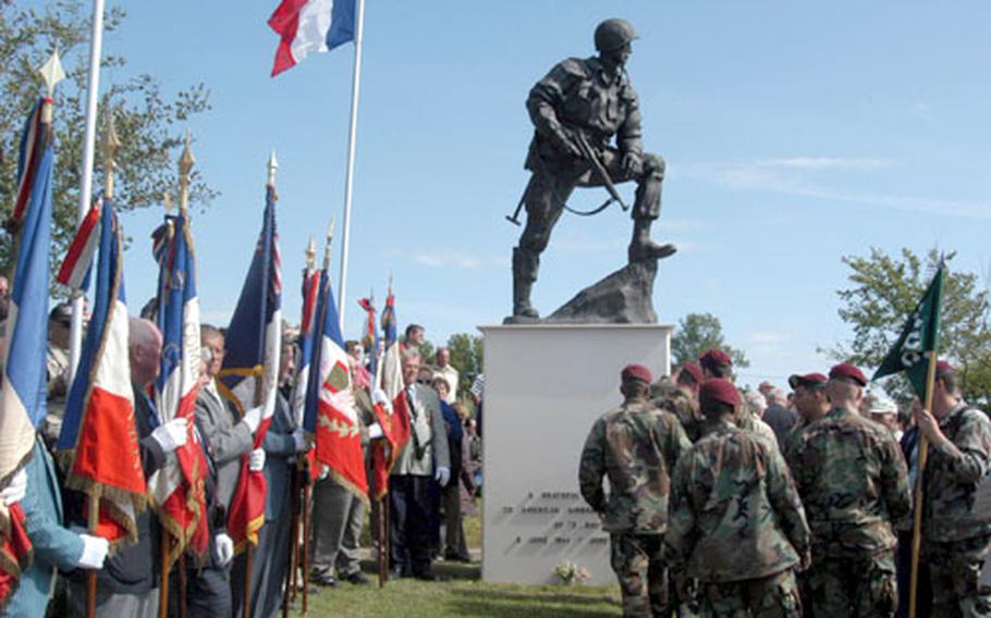 French veterans and American paratroops gather at the statue of a U.S. paratrooper at La Fière, near St.-Mére-Eglise.