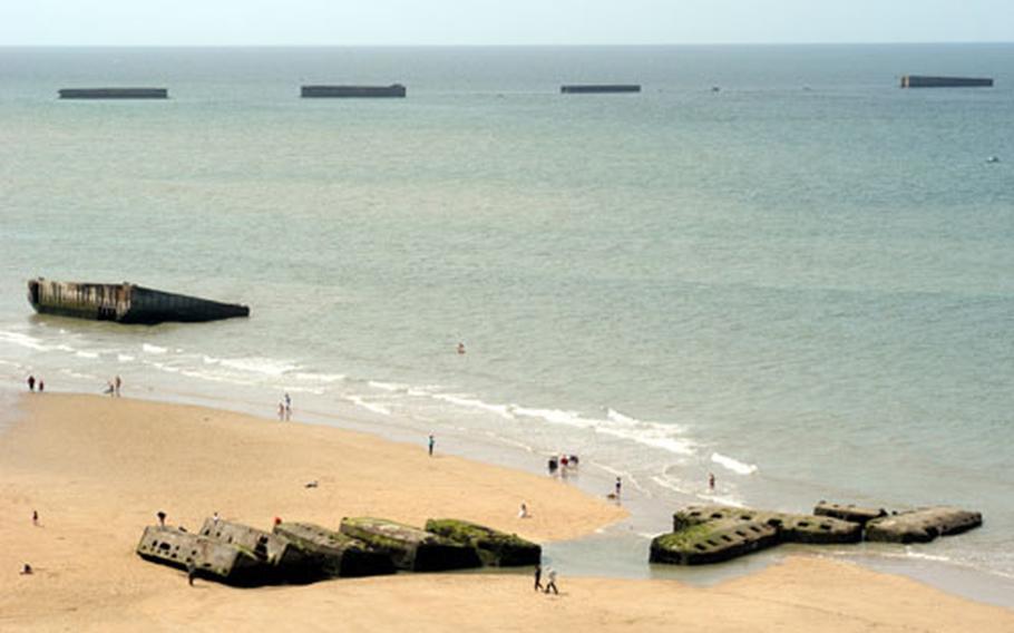 Beachcombers are dwarfed by the huge concrete leftovers of Port Winston, the artificial harbor at Arromanches. These big camions were dragged by tow ships across the English Channel and dropped into position to form an artificial harbor, allowing the British to bring in large amounts of supplies safely.