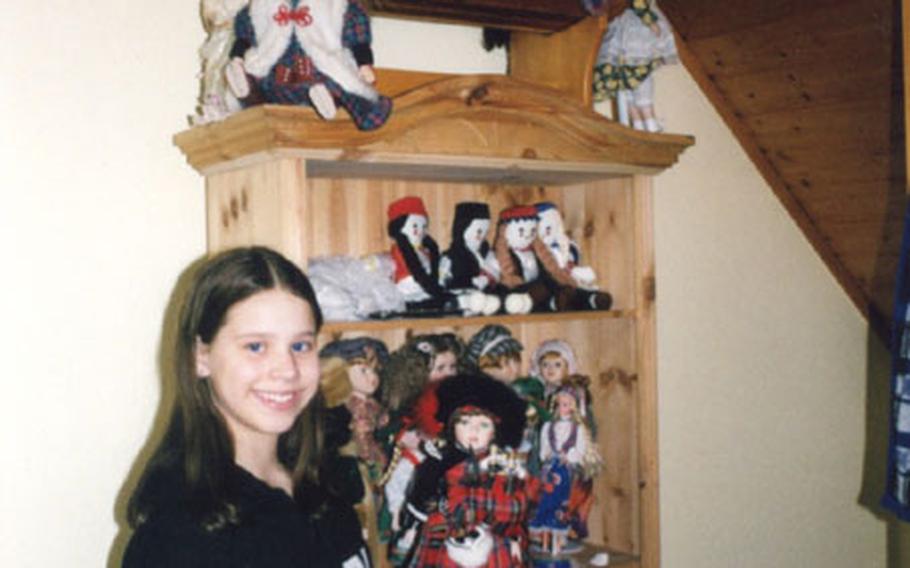 Casey McDonald, 12, stands next to a shelf holding her doll collection assembled through her travels to 21 different European countries.