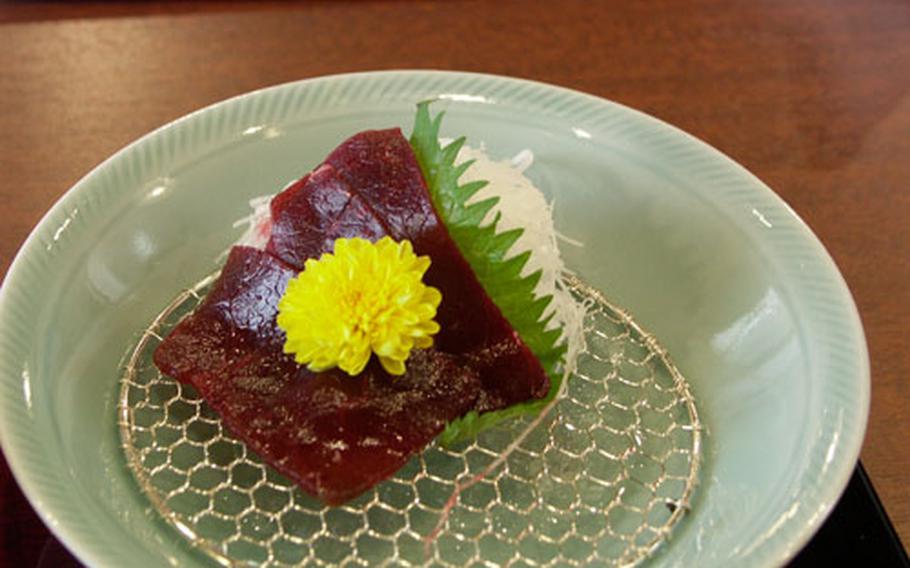 Sashimi of whale meat served at Yushin — a whale-meat shop and restaurant in Asakusa, Tokyo. The meat is tender and has no smell. On the top of the sashimi are chrysanthemum flower petals.