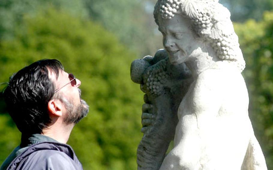 A visitor to Houghton Hall in Norfolk, England, gets up close and personal with one of the statues on the grounds of the great 18th-century home.