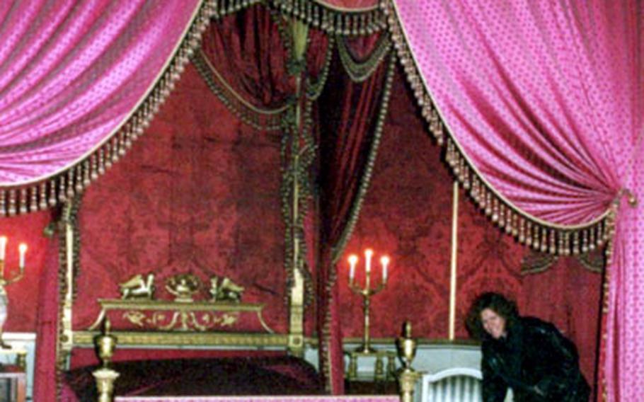 A tour guide points out a chair that was used as a toilet in one of the royal bedrooms of Germany’s Schloss Ludwigsburg.