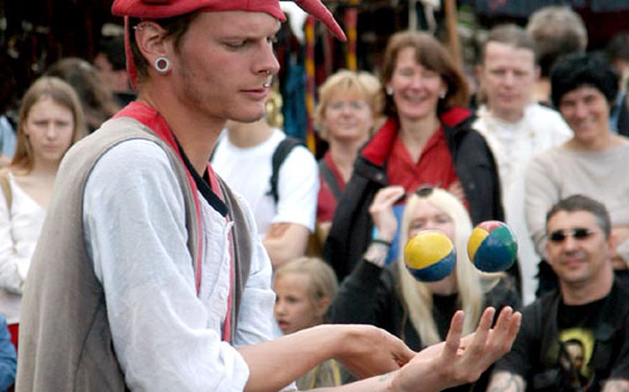 A juggler delights a crowd of modern-day onlookers.