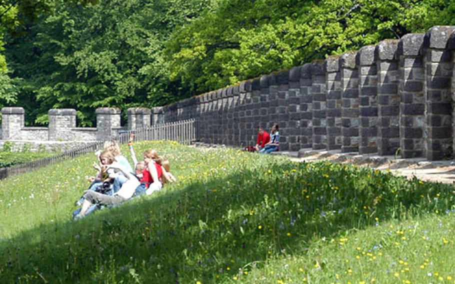 A group of schoolchildren sit along the ramparts of the Saalburg, a rebuilt Roman fort.
