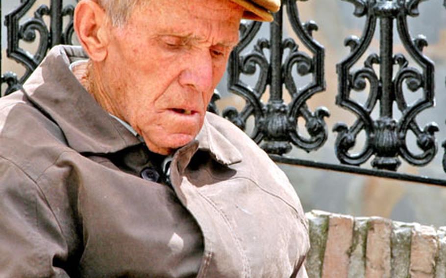 An older citizen of Casares counts his money and enjoys a rest at the town square.