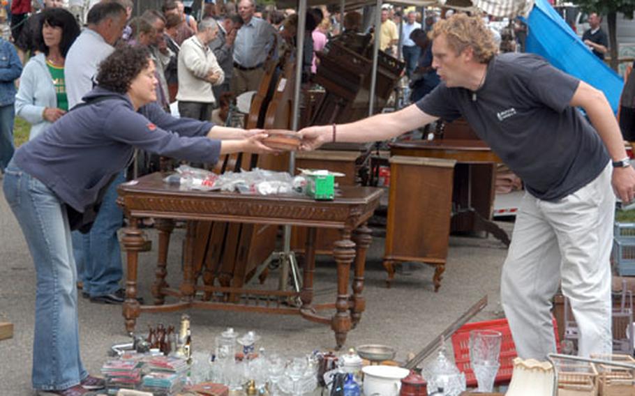 Making a sale at the antique flea market in Tongeren, Belgium. The market, said to be the biggest in the Belgium-Netherlands-Luxembourg region, takes place every Sunday from 7 a.m. to noon.