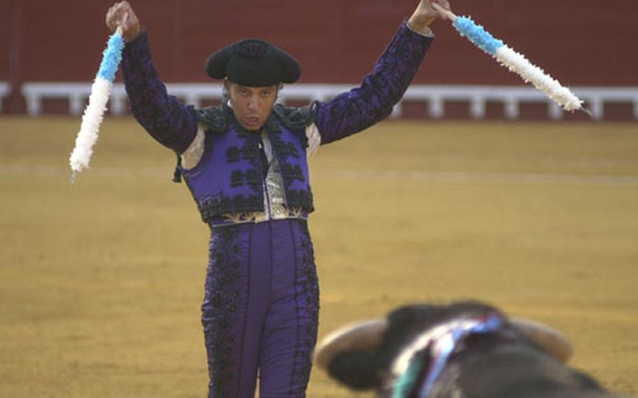 A banderillero prepares to stick a pair of barbed sticks, or banderillas, into the back of a bull during a bullfight July 4, 2004, in El Puerto de Santa Maria, Spain.