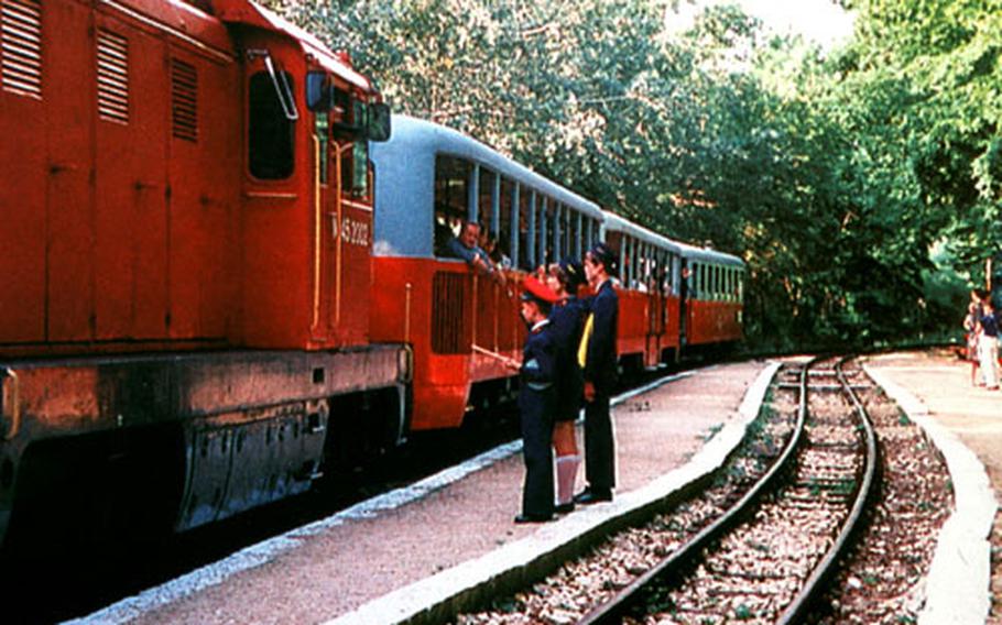 The Children&#39;s Railway makes a stop at one of the stations along the approximately 7-mile-long route. The young crew performs most of the operations for the train, under the supervision of adults.