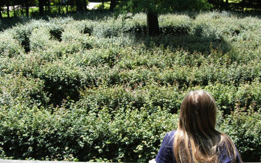 A girl watches from an observation platform as her classmates navigate their way through the maze at Schönbusch Park, on the outskirts of Aschaffenburg, Germany.