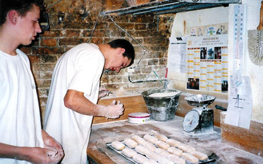 Young apprentices prepare small loaves of dough for baking at the Poilâne Bakery in Paris.