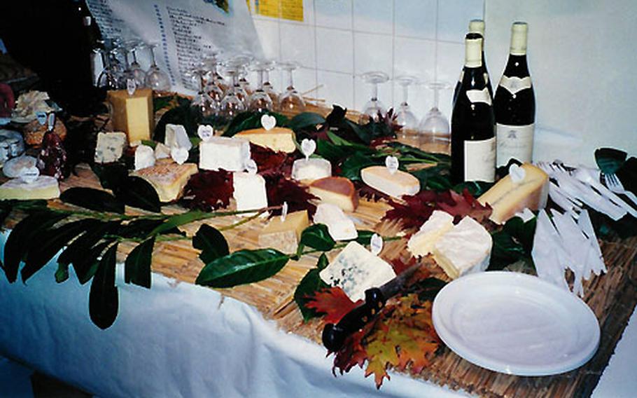 A table laden with wine and cheese varieties awaits members of the “Paris — A Culinary Delight” tour at La Ferme Saint-Aubin in Paris.