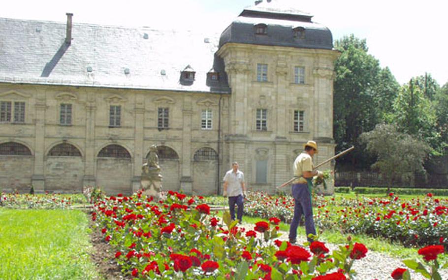 Workers tend the rose gardens in the courtyard of the Baroque monastery at Ebrach, Germany.