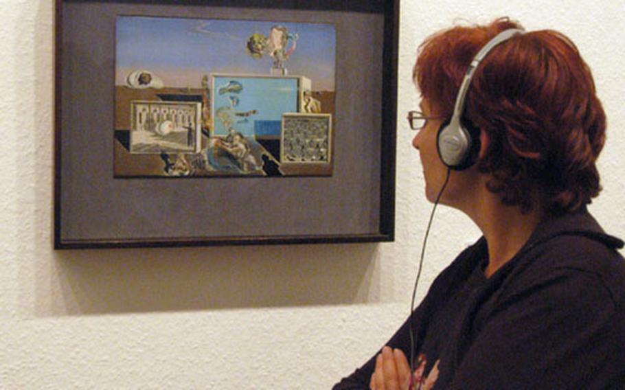 A visitor to the MoMA show in Berlin checks out Salvador Dali&#39;s "Illumined Pleasures", while listening to an audio tour of the exhibit.