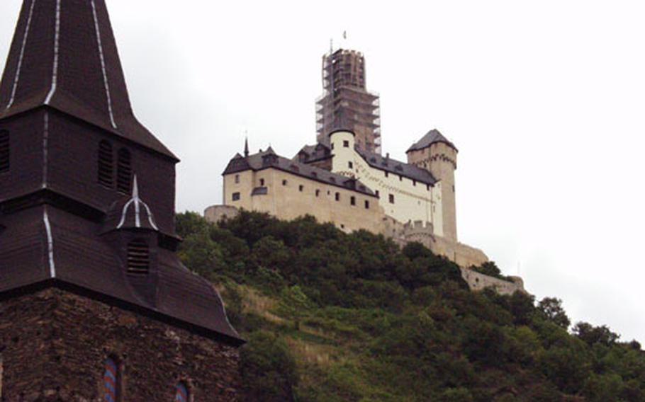 Even wearing its cocoon of scaffolding, Marksburg Castle&#39;s distincitive wedding-cake keep towers over the Rhine Valley town of Braubach and its "Obertor" (left).