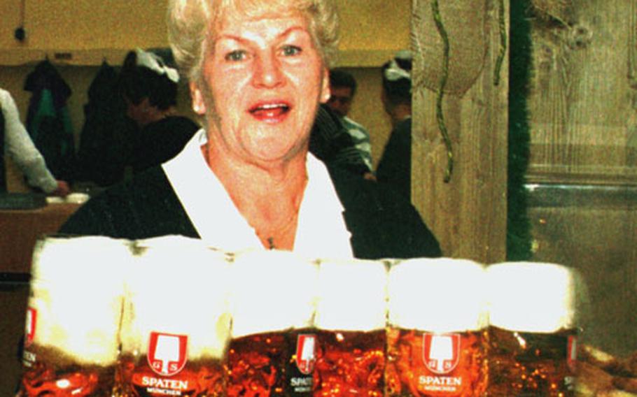 A server carries one-liter mugs to thirsty visitors at the Oktoberfest.