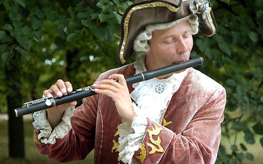 Dressed in period costume, a musician entertains visitors to Park Sanssouci.