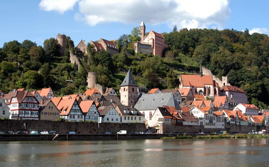 Burg Hirschhorn towers over the town and the Neckar river. At center is the Mitteltor, once a city gate, and now the bell tower of the Catholic church. Half-way up the hill at right is the Klosterkirche, once part of a Carmelite cloister.