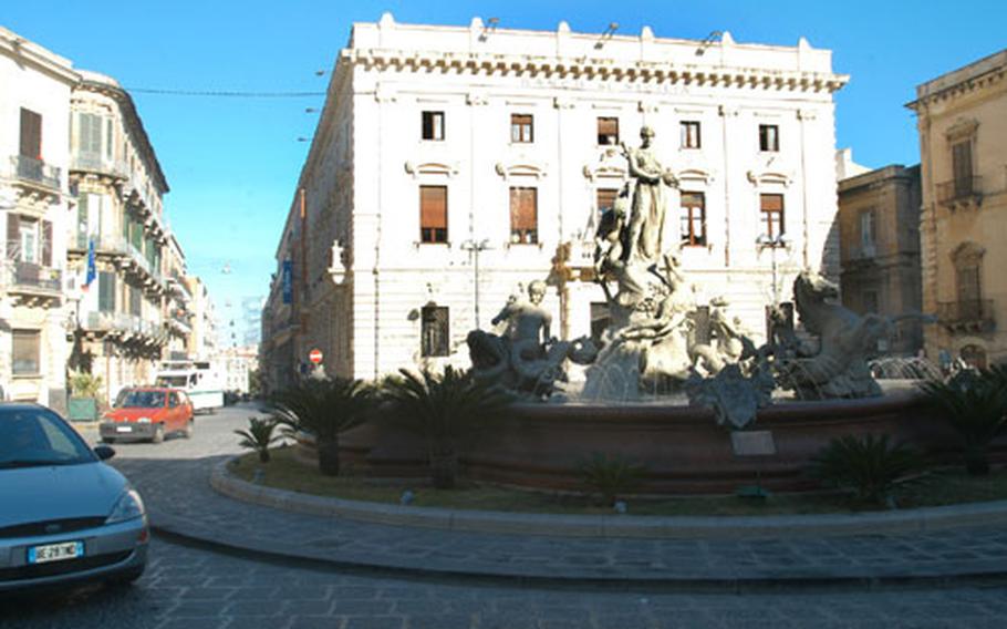 Traffic winds around a fountain in central Syracuse&#39;s Piazza Archimide. The fountain is located at the end of the town&#39;s main shopping street.