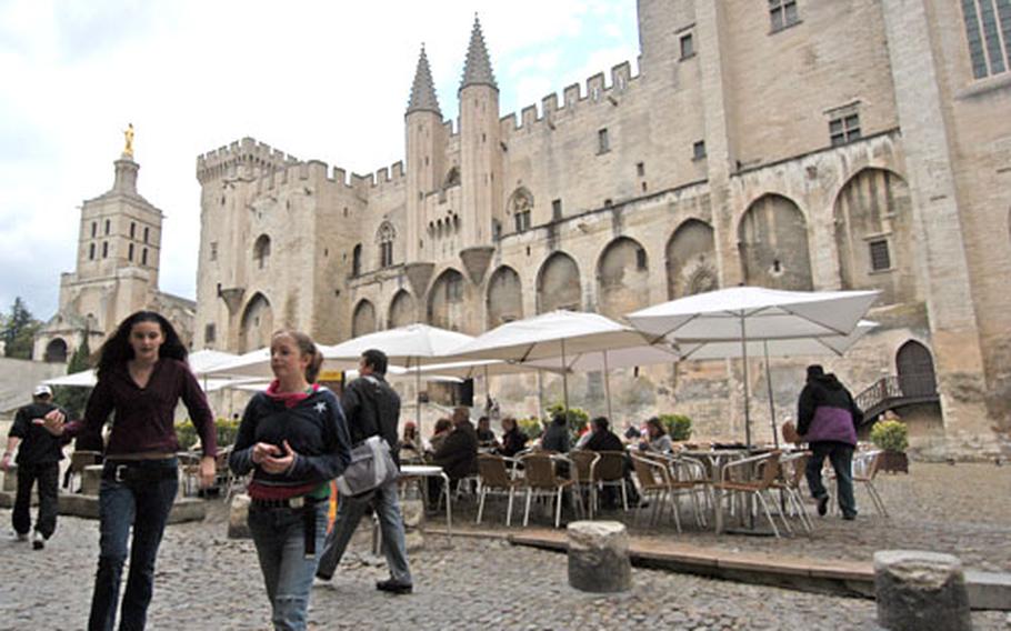 The Palais des Papes in Avignon; at far left is the Notre-Dame-des-Doms cathedral. The cafe on the palace square is a popular place to cool the feet after a tour of the papal palace.