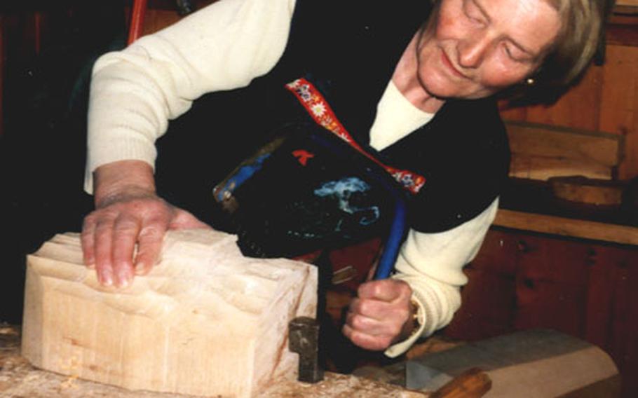 Agnes Rieder of Wiler, Switzerland, carves a mask from a piece of aged pine.