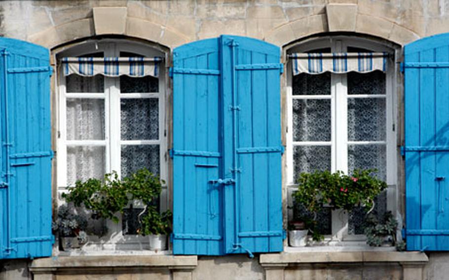 Blue shutters give a splash of color to a building across from the arena in Arles, France.