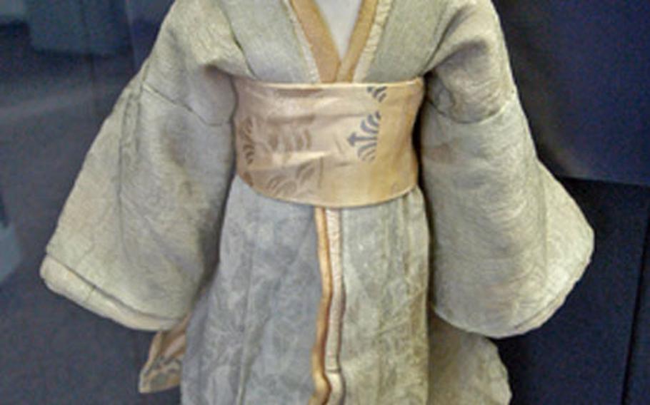 A Japanese doll from 1840 is dressed in a traditional Kabuki costume.