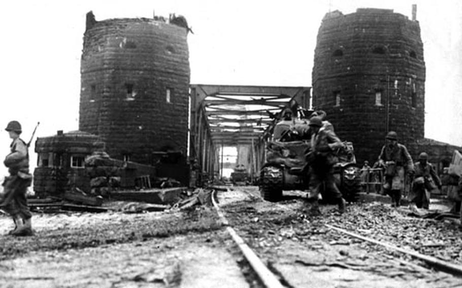 U.S. soldiers stand guard as engineers from the 9th Armored Division strengthen the bridge at Remagen, Germany, in March 1945. The bridge was originally for railroad traffic, but planks were placed across the tracks so wheeled vehicles could cross. The Germans, who tried to destroy the bridge with explosives and air attacks, finally succeeded, killing 28 engineers who had been trying to strengthen the bridge.