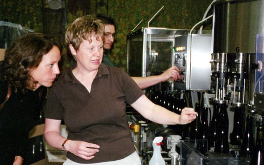 Sabine Mosbacher-Düringer shows a visitor the bottling process at her estate, Weingut Mosbacher in Forst, Germany, which produces Riesling wines.