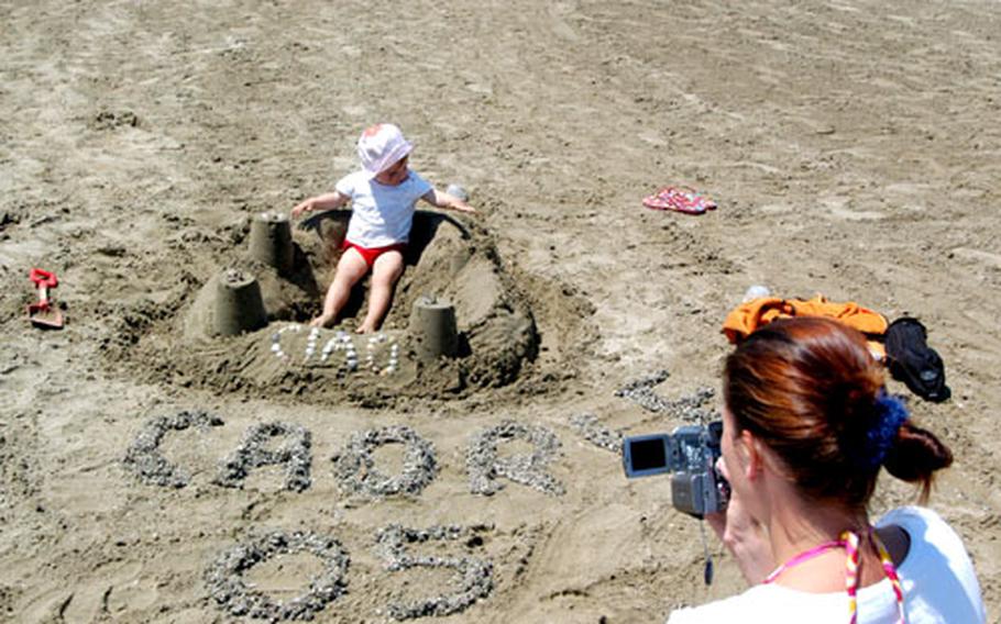 Sandra Stross films her 15-month-old daughter, Miriam, tearing down the sand castle that she and her husband, Wolfgang, made on the beach at Caorle, Italy.