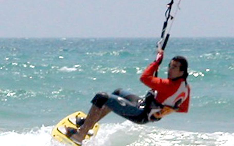 Juan Antonio Martin Escobar, an experienced kitesurfer, executes a jump before gliding in for a landing on Sancti Peteri beach.