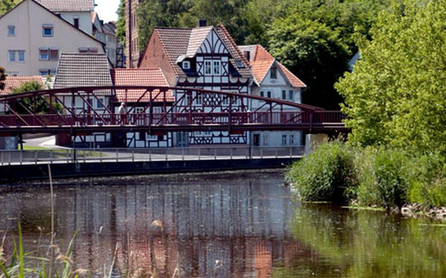 The Schulberg (school hill) and houses on the bank of the Werra are reflected in the river. The tower at top right is the Karlsturm, sometimes called the black tower.