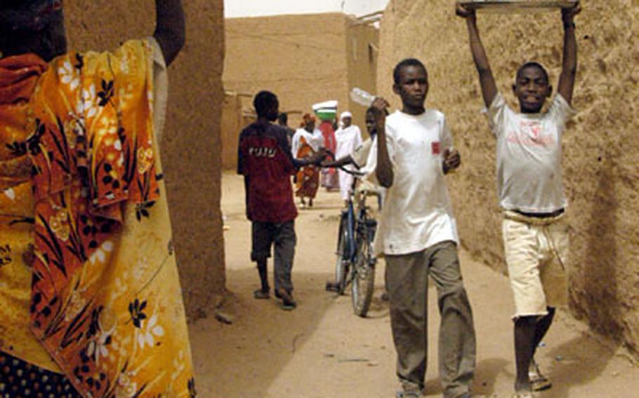 Walkways between the houses in Agadez are teeming with residents carrying goods to their homes or just wandering about.