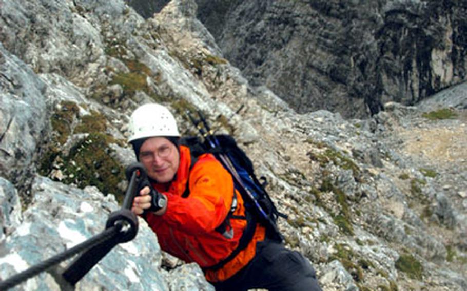 Helmut Grüninger, a weekend warrior from Munich, uses steel cables to climb up the peak of the Alpspitze Mountain. Guides recommend using a helmet and harness to clip into the steel cables for safety during the steep and rocky climb to the top.