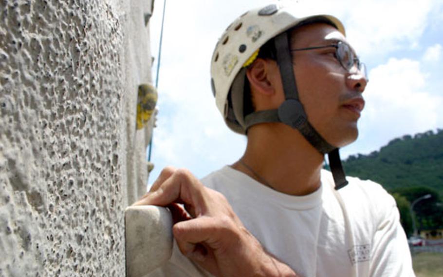 Instructor Michael Dong demonstrates one of the hand positions students should use to help pull themselves up during rock climbing. However, most of a climber’s strength will come from their legs and lower body.