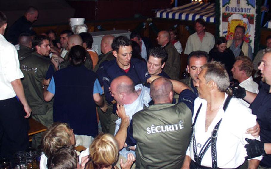 A late-night scuffle, like this one at last year’s festivities, will be quickly broken up by burly security guards.