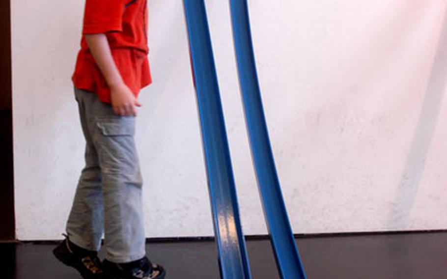 Lukas, an 8-year-old German boy from Bavaria, watches a metal ball roll down a ramp at the Mathematikum in Giessen, Germany. The Mathematikum offers scores of interactive display stations.