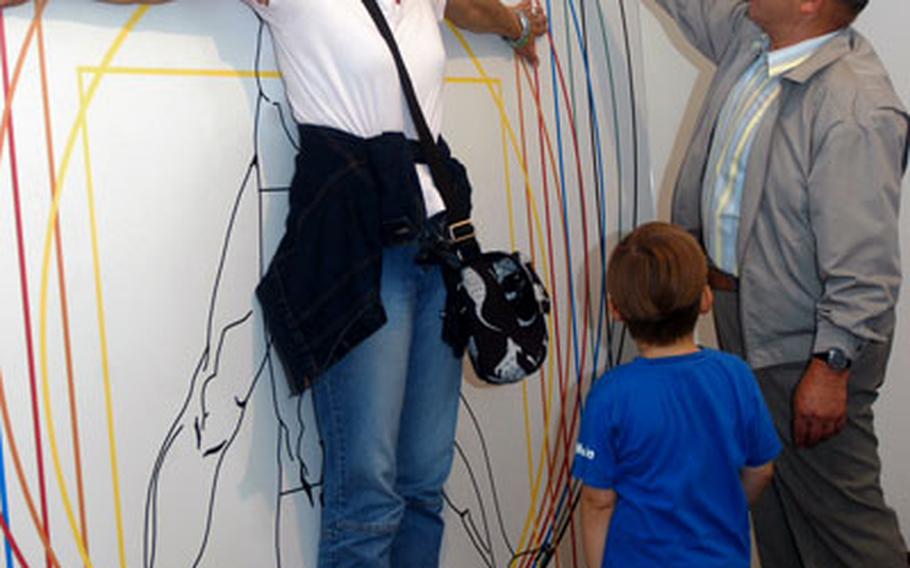 A German family tries an exercise that uses Da Vinci’s “Vitruvian Man.” The museum draws about 150,000 visitors each year.